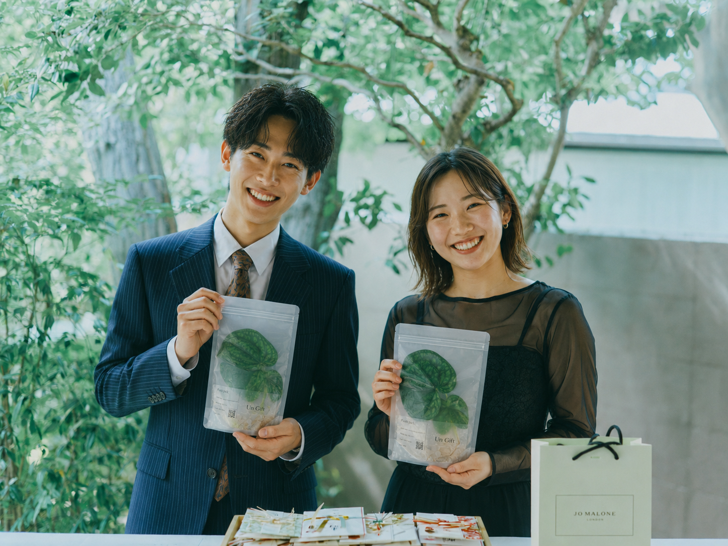 Un Giftの植物パッケージを手にする新郎新婦